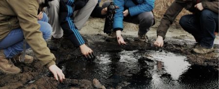 Group of students at an “oil seep” in the Ukraine. Surface shows of oil and gas are very common naturally-occurring phenomena.